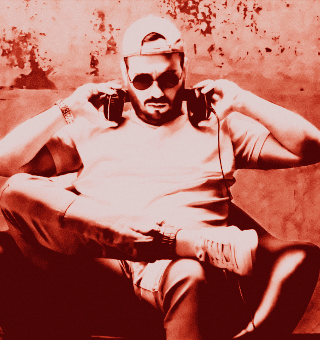 MAURE$ wearing sunglasses and headphones, relaxing outdoors.