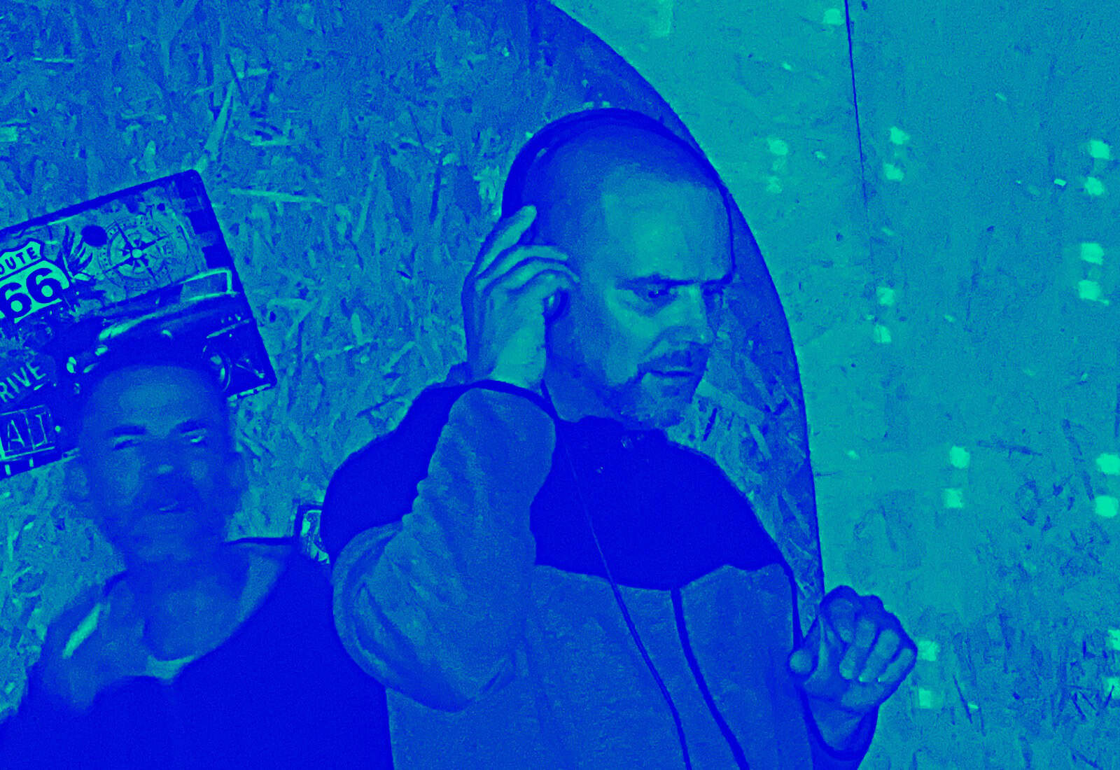 DJ performing at a music event with headphones and turntables.